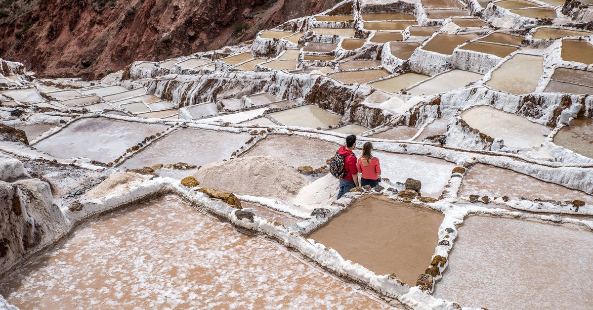 Visiting salt flats in Bolivia from Chile - Tourists Visiting Ancient Saline Terraces in Andes Peru