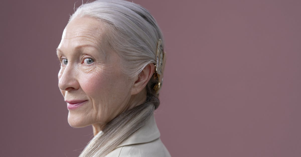 Visitor visa for Grandmother - Woman in White Coat Smiling