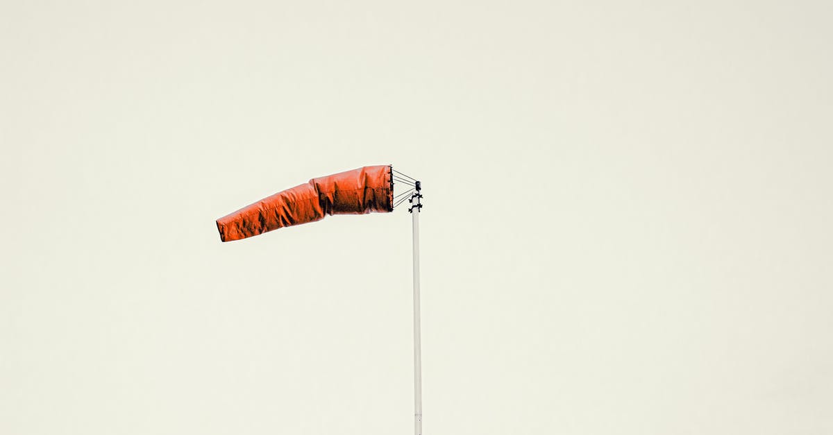 Voluntourism - how to evaluate - Red windsock on pole against gray sky