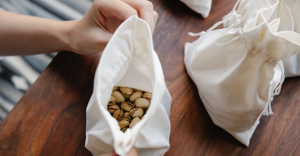 Vueling hand bag rules - Faceless person demonstrating recycling bag with pistachios