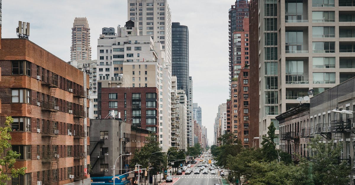 Waiting area near 7th avenue, 27th street, New York - New Your City street with vast busy road between contemporary typical buildings on clear day