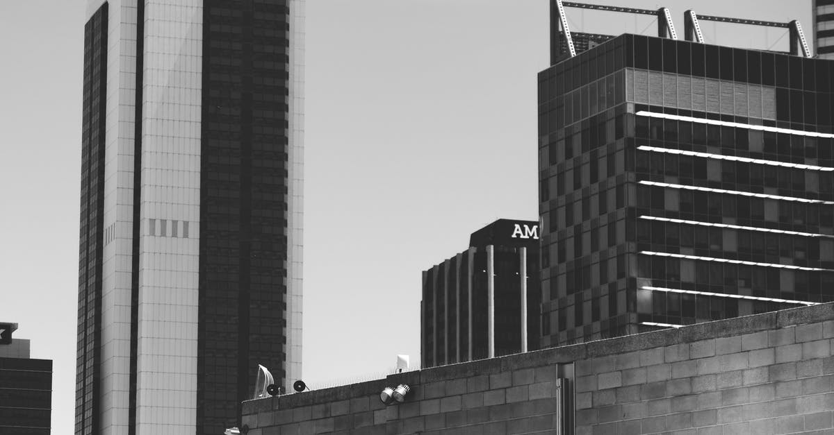 Waiting area near 7th avenue, 27th street, New York - Black and white exteriors of different modern buildings located in commercial district of city against cloudy sky