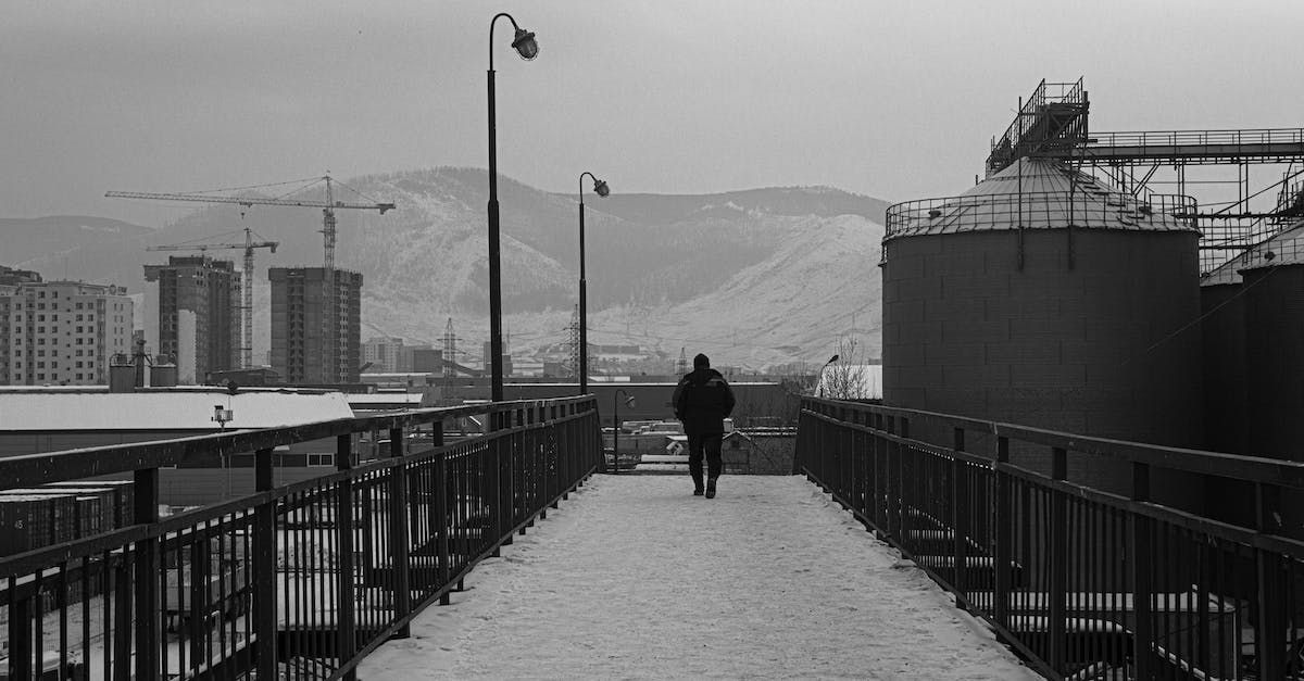 Walking back down Grouse Mountain, after doing the Grouse Grind? - Man Walking on a Bridge in Winter in City 