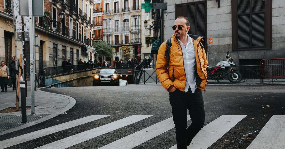 Walking on a road in Spain - Photo of Man Walking on Pedestrian Crossing