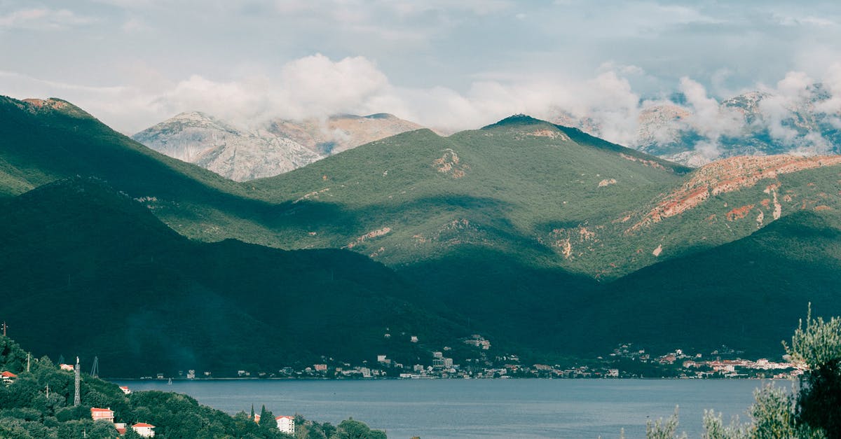 Wallpaper picture location - Lake with mountains - Breathtaking view of calm lake among green hills and village in mountainous area