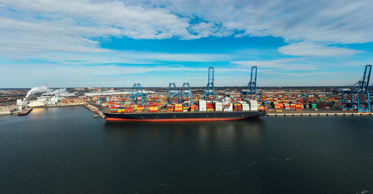 Watching container ships in SF bay area? - High angle of cargo ship moored in modern industrial port under blue cloudy sky in daylight