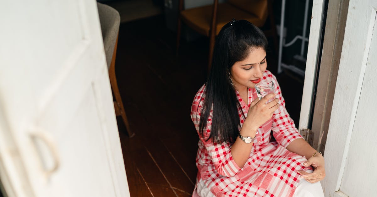 Water-damaged Indian passport expiring in November 2020 - Young brunette drinking water while sitting in doorway