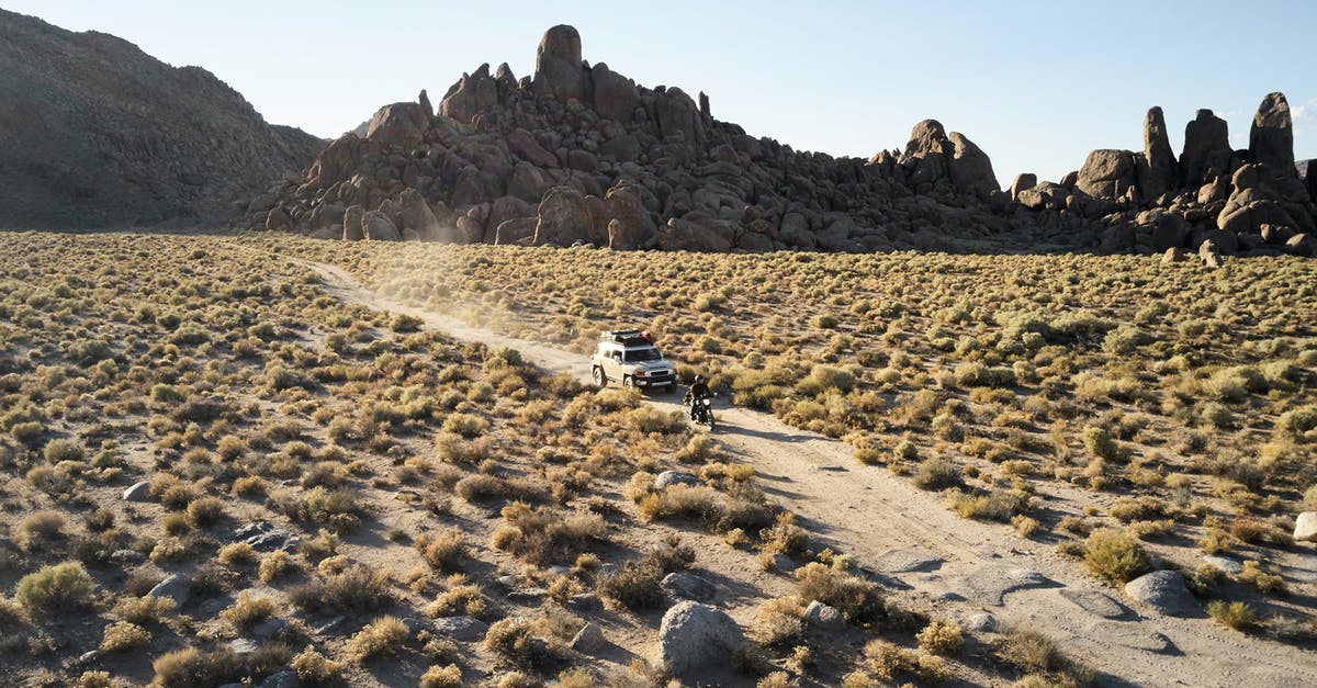 Ways to travel from Mexico to South America over land [closed] - From above amazing rocky landscape of semidesert and narrow rural road with driving jeep and bike under evening sun