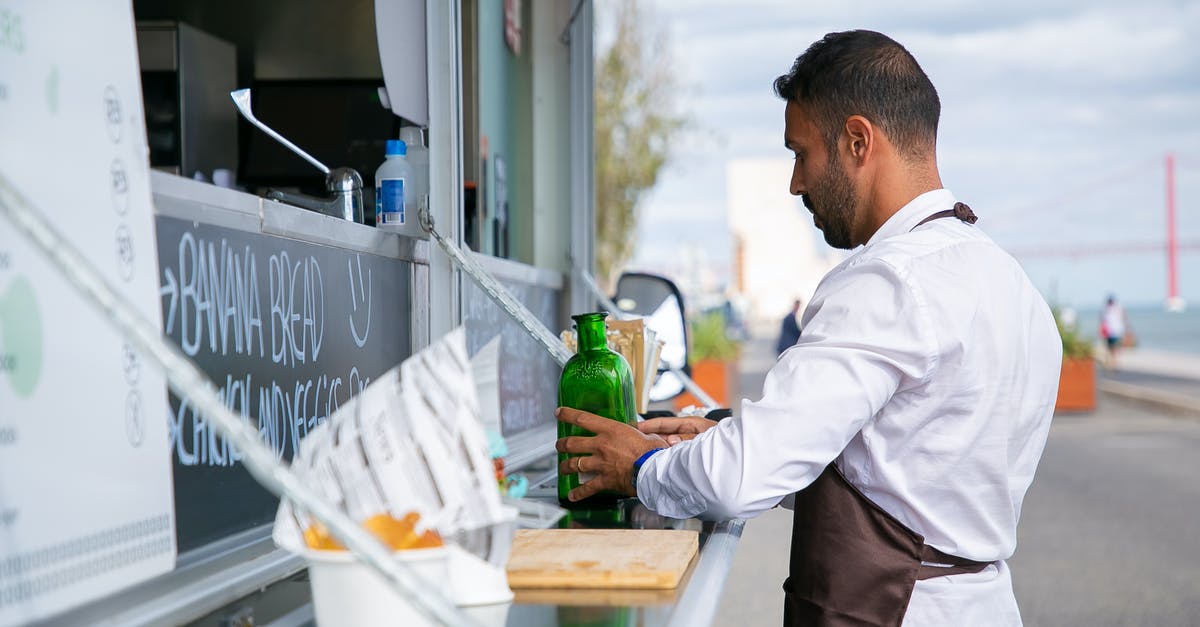 Website to arrange rides with trucks - Ethnic man putting glass bottles on counter