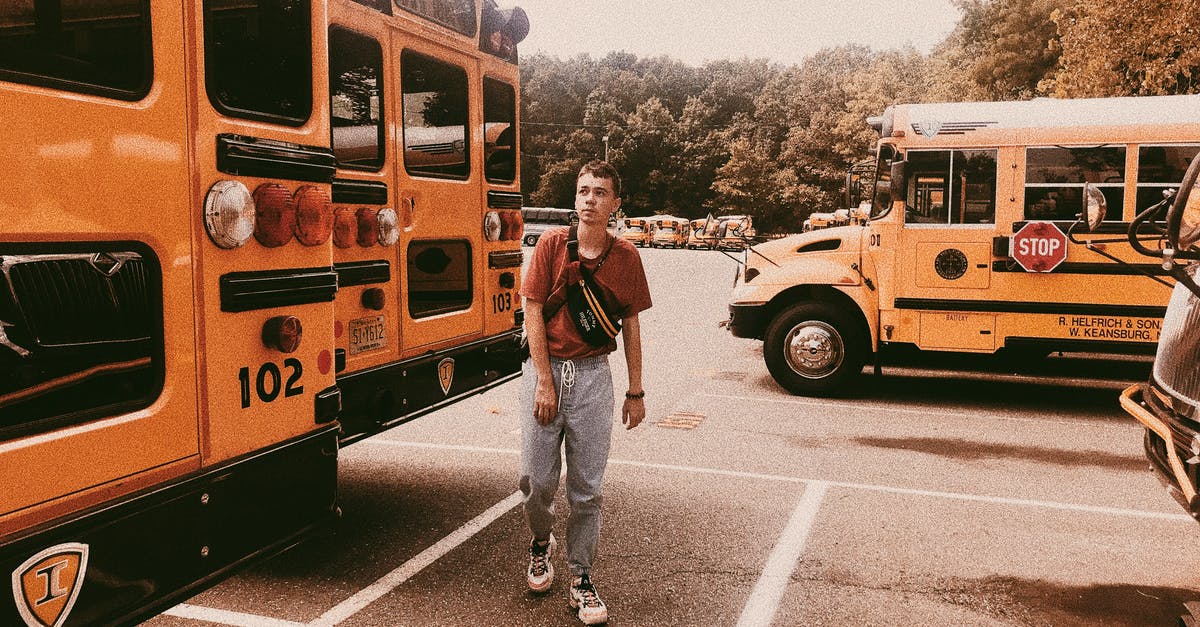 Weekend parking at PATCO stations - Stylish young man walking on parking lot with school buses