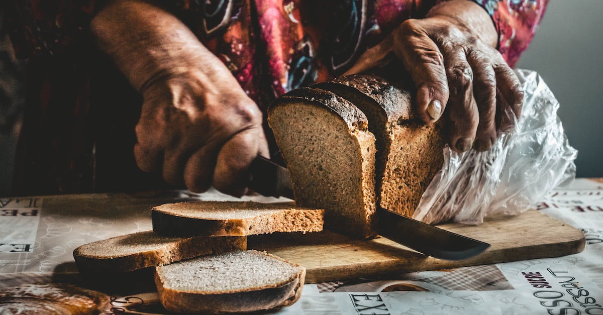 What's a good substitute for a pocket knife that can be carried on-board a plane? - Close-Up Shot of a Person Slicing a Bread on a Wooden Chopping Board