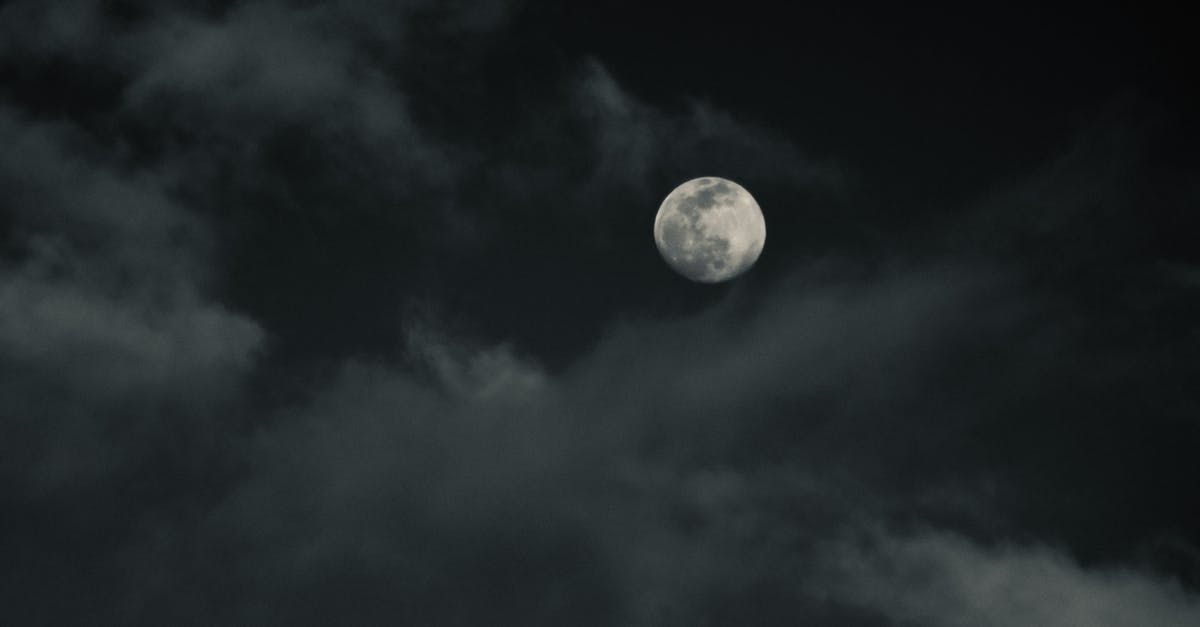 What's the closest SCUBA spot to Chiang Mai? - From below of moon with craters on thick clouds floating in dark sky in evening