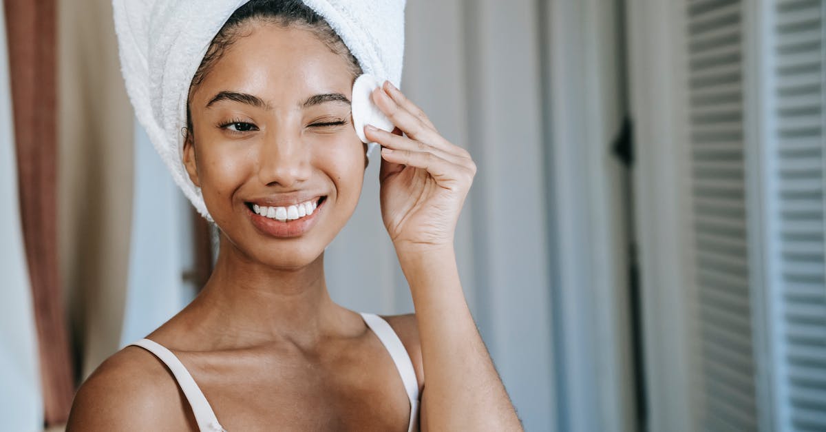 What's the courtesy: wipe off the wash basin? - Smiling ethnic woman wiping face skin in morning