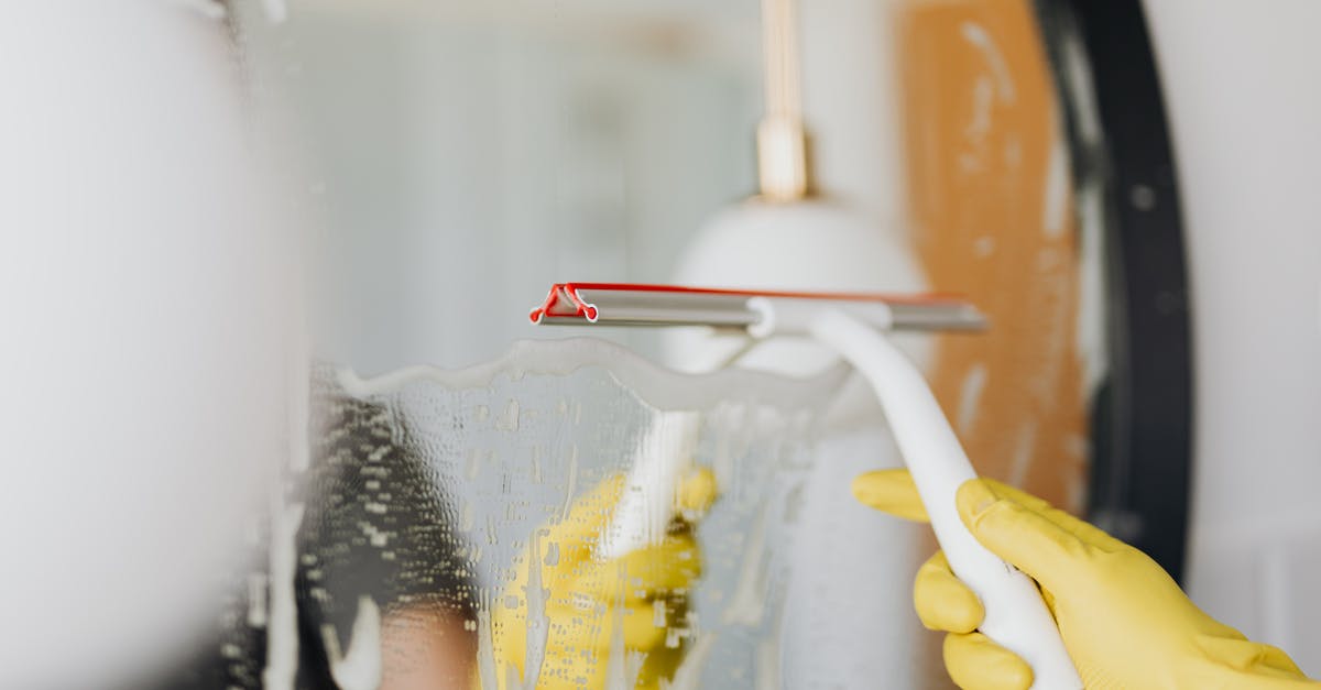 What's the courtesy: wipe off the wash basin? - Faceless person removing water from mirror