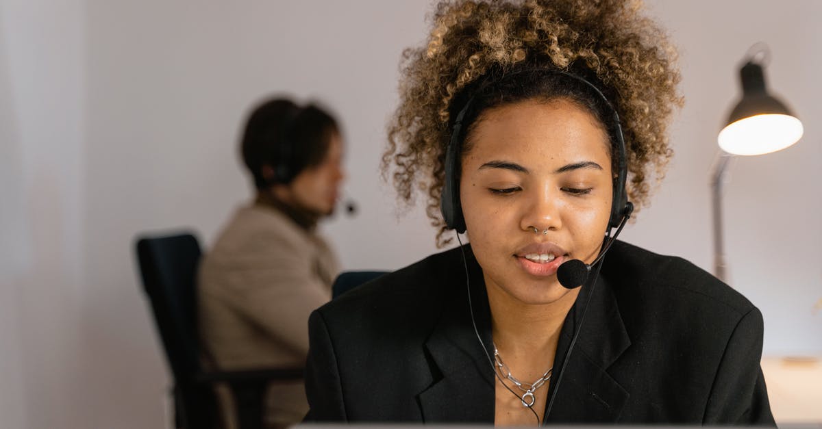 What's the most cost-effective service for calling landlines while travelling? - Woman in Black Blazer Sitting on Chair