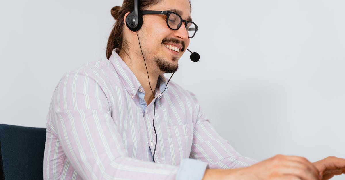 What's the most cost-effective service for calling landlines while travelling? - Man in Long Sleeve Shirt with Black Headset and Mouthpiece