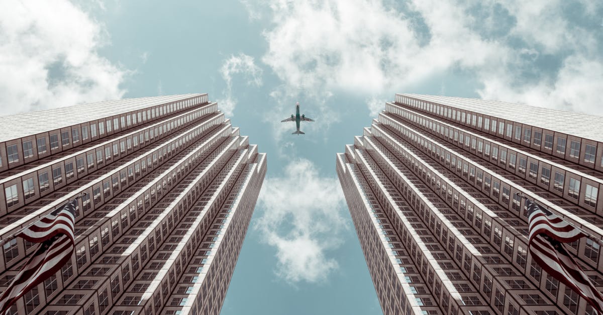 What's the penalty fee for rescheduling a flight on Garuda Airlines after buying the ticket? [closed] - Worm's-eye view Photo of Plane Between Two High-rise Buildings