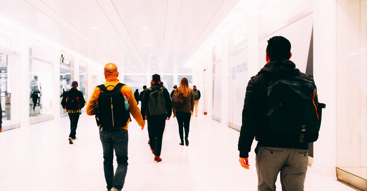 What architectural and design philosophies govern airport layouts? [closed] - People Walking On A Hallway