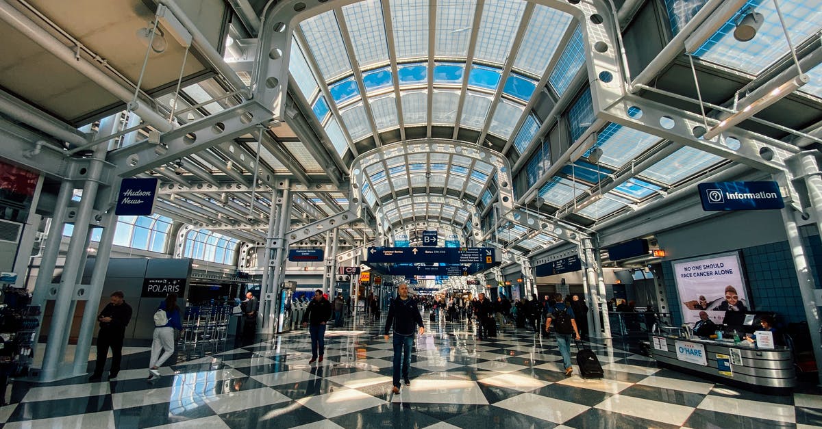 What architectural and design philosophies govern airport layouts? [closed] - Contemporary style building interior with many symmetric lamps on ceiling and metal beams above tile floor with people strolling in spacious hall