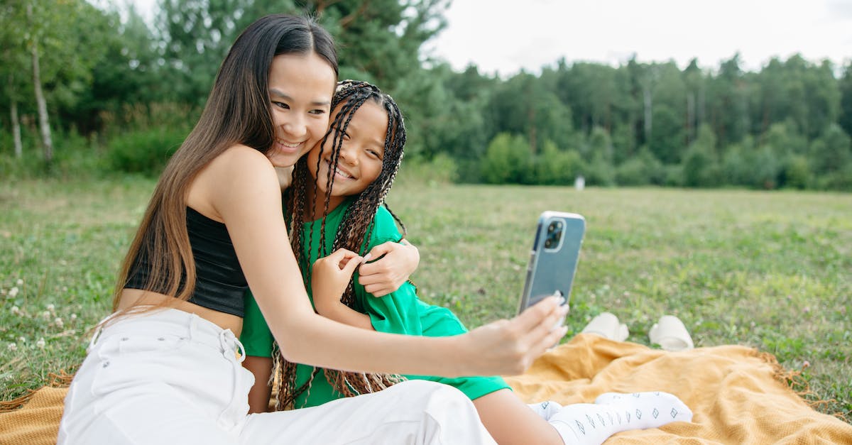 What are good holidays for a disabled adult and a small child? - A Mother and Daughter Taking Selfie while Sitting on a Picnic Blanket