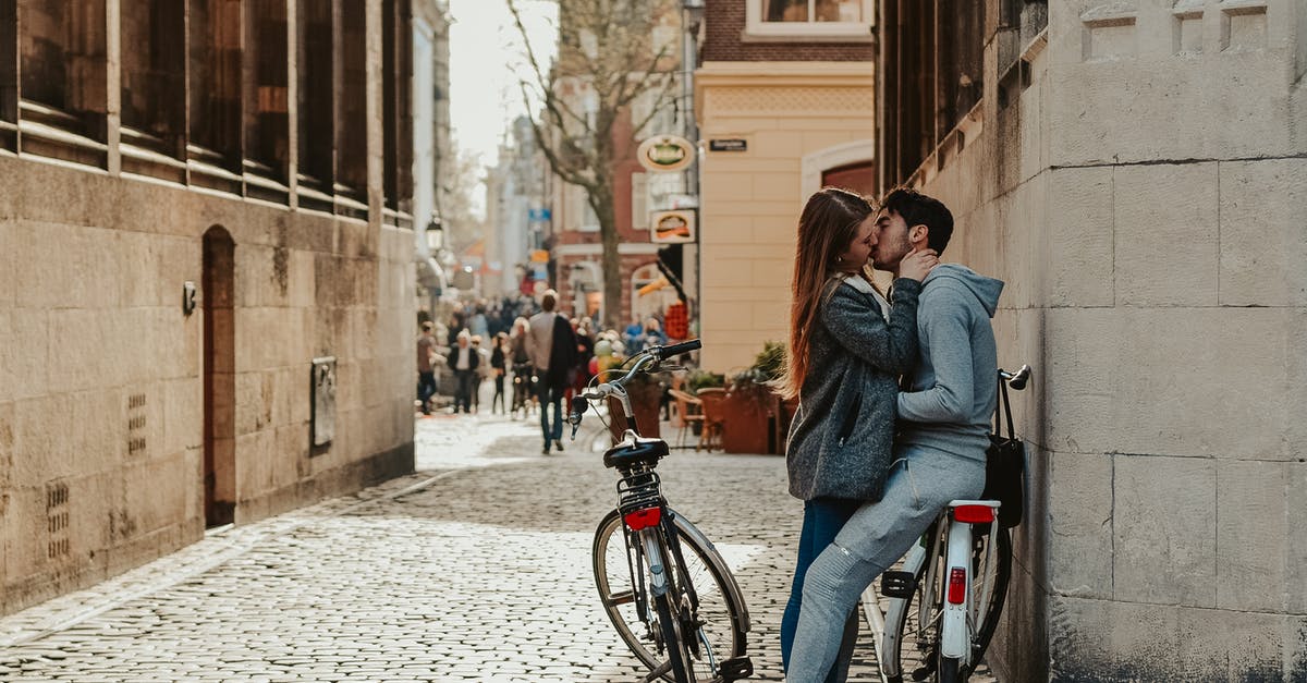 What are my options for accommodation whilst travelling by bicycle [closed] - Romantic couple with bicycles kissing on old street