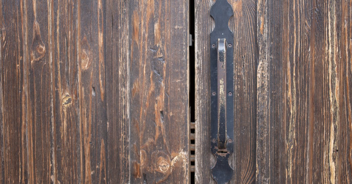 What are safe uses of non-potable water? - Closeup of weathered old rusty brown locked wooden door with cracks on surface with aged metal handle