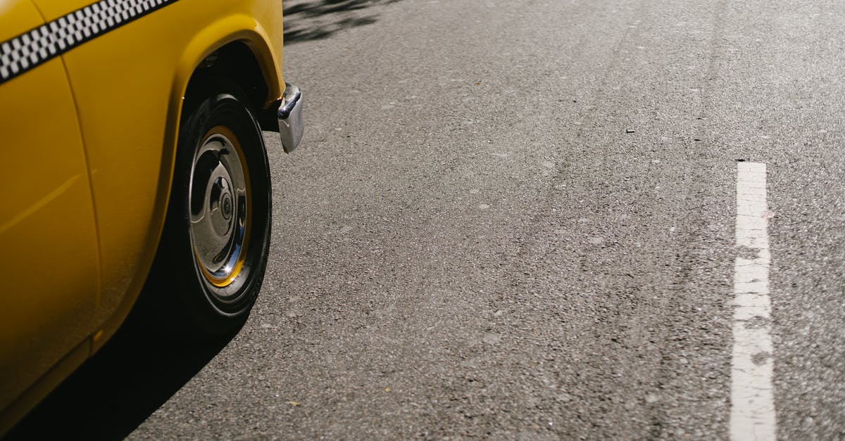 What are the current regulations to move between islands in Maldives? - From above of shiny yellow cab driving along street on asphalt roadway in modern city in soft daylight