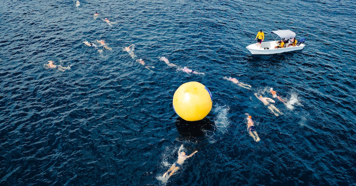 What are the Jordanian visa rules for travellers entering from Israel? - Aerial view of swimmers taking park in race and swimming around big yellow inflated ball in sea water