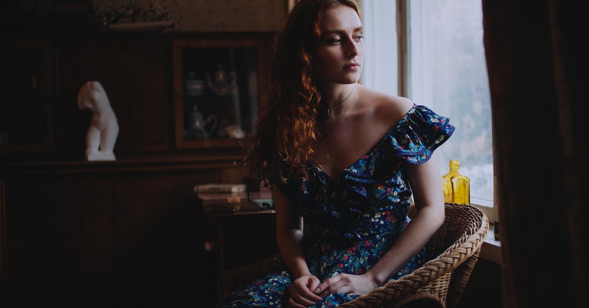 What are the limitations of a ScotRail Off-Peak Day Ticket? - Woman in Blue and Yellow Floral Dress Sitting on Brown and Black Leopard Print Chair