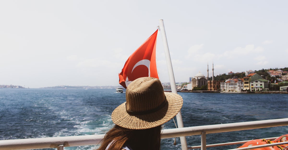 What are the practical implications for the flag of a ship? - Woman Wearing Brown Sun Hat Near Turkey Flag and Body of Water