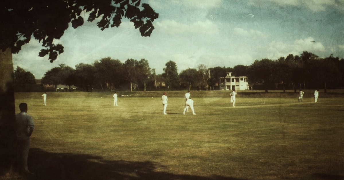 What are the requirements for a UK passport photo? - People in White Clothes Playing Cricket on Field