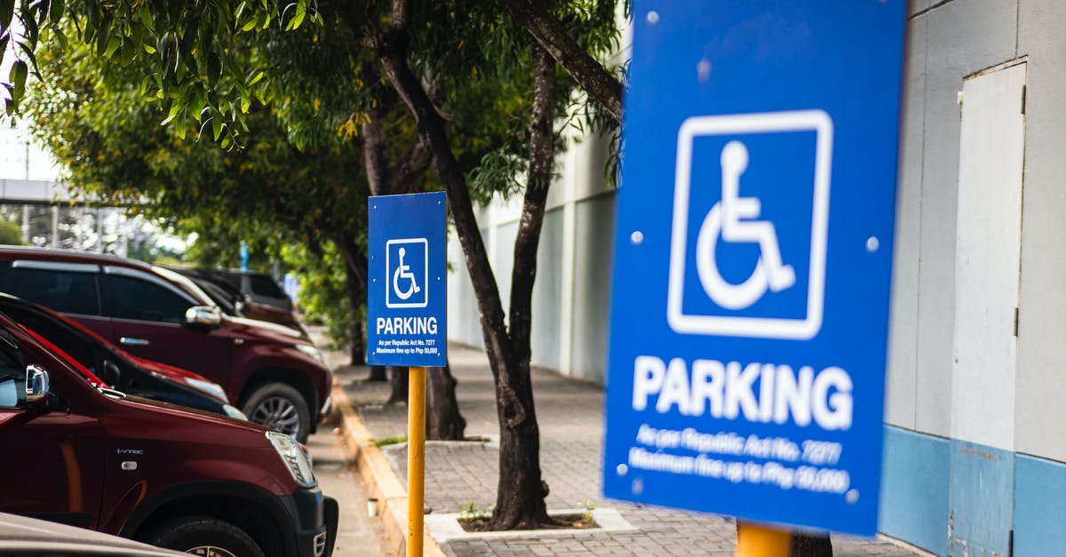 What are the restrictions imposed by the Sharia law in Aceh, Sumatra? - Disabled parking sign on street with transport