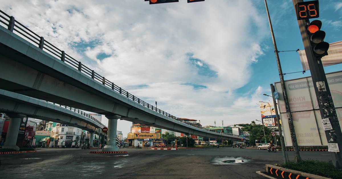 What are the rules around intersections with flashing lights? - Low angle of empty asphalt crossroad with red traffic light with timer in center of city