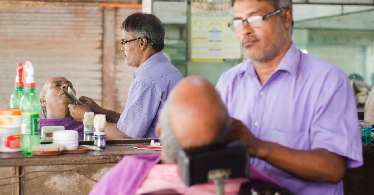 What are the shaving options for the carry-on traveler? - Man in Pink Scrub Suit Sitting on Barber Chair