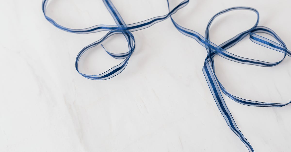 What are these long objects in Jakarta? - From above of chaotically arranged blue long ribbon on white marble surface of table