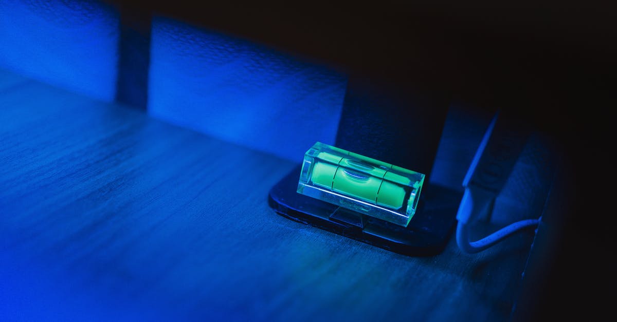 What are these small green rocket-shaped objects floating in the Danube? - Small illuminating green neon bubble level placed on monitor stand in dark room