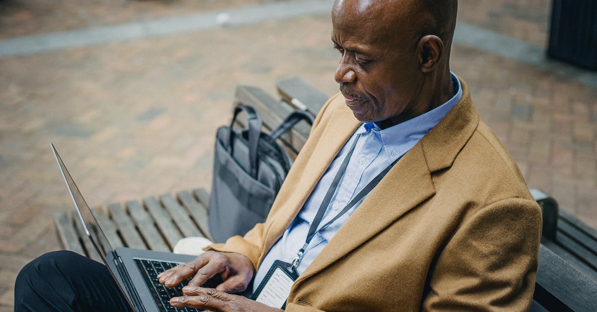 What are typical internet connection speeds in Colombia? - Crop black businessman sitting on bench and using laptop