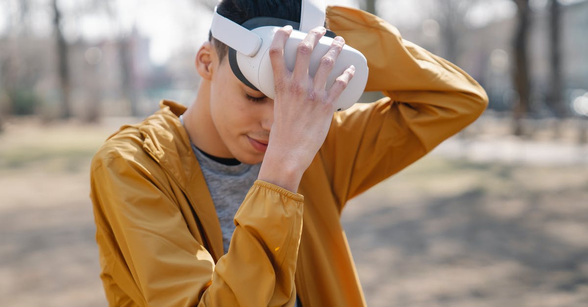 What are virtual ways to travel? [closed] - Man with closed eyes putting on VR device against blurred background of autumn city park in daytime