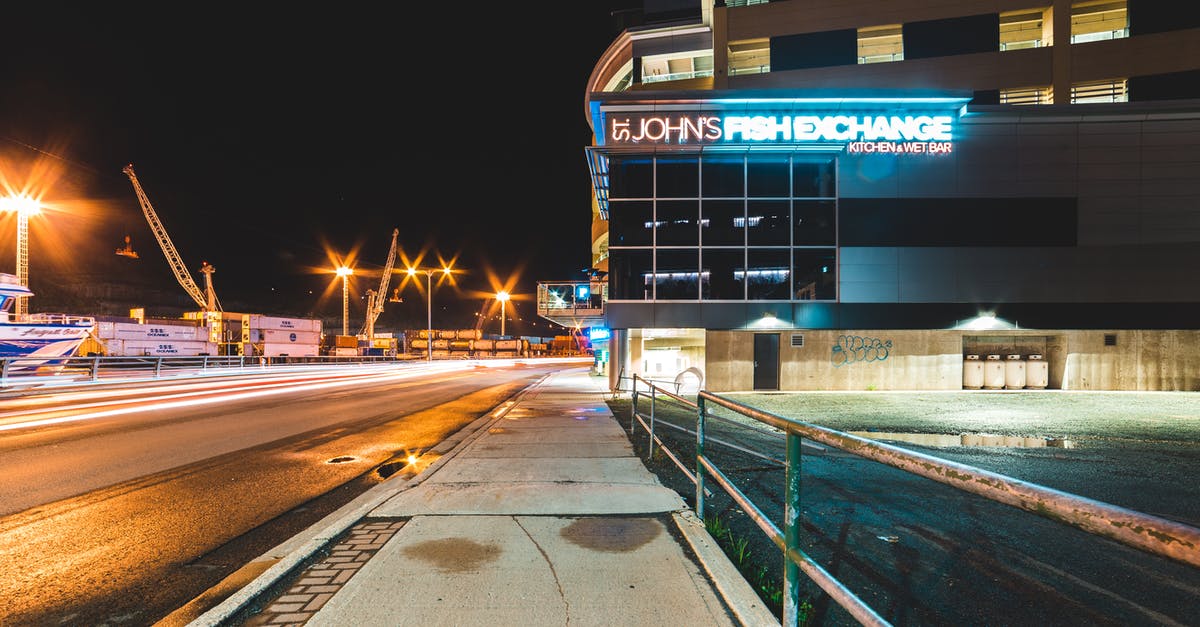 What area is considered to be Marseille's city centre? - Contemporary building on illuminated city street near port at night