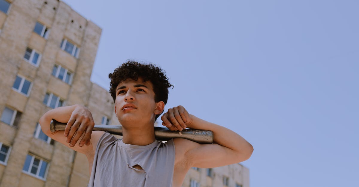 What building is this? - Man in Gray Tank Top Holding His Hair