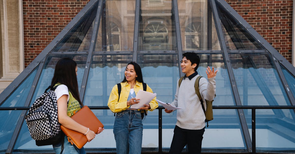 What building is this? - Woman in White Long Sleeve Shirt and Blue Denim Jeans Standing Beside Woman in Yellow Shirt