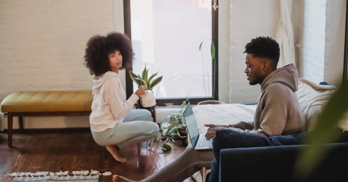 What can I expect when bringing in my netbook to China? - Black couple spending time in light apartment in daytime