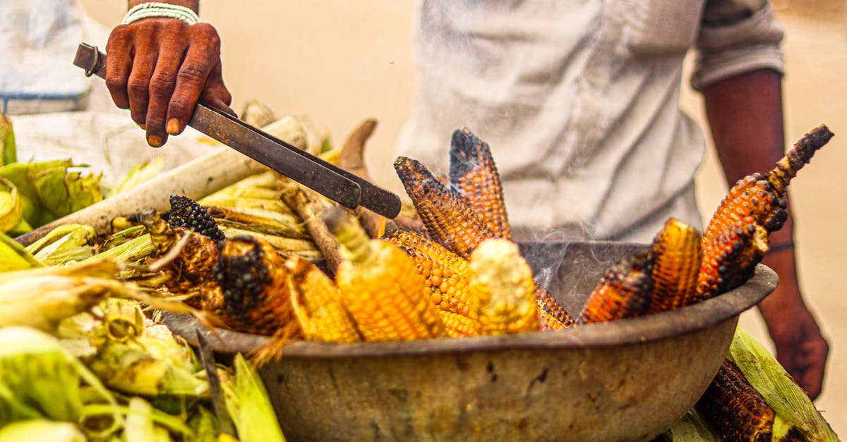 What city is this city scape? [closed] - Person Holding Brown Wooden Handle Gray Metal Pan With Corn