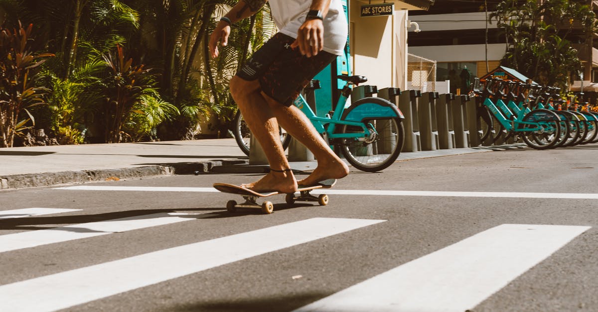 What city is this? [closed] - Man in White Shirt and Brown Shorts Riding Blue Bicycle on Road