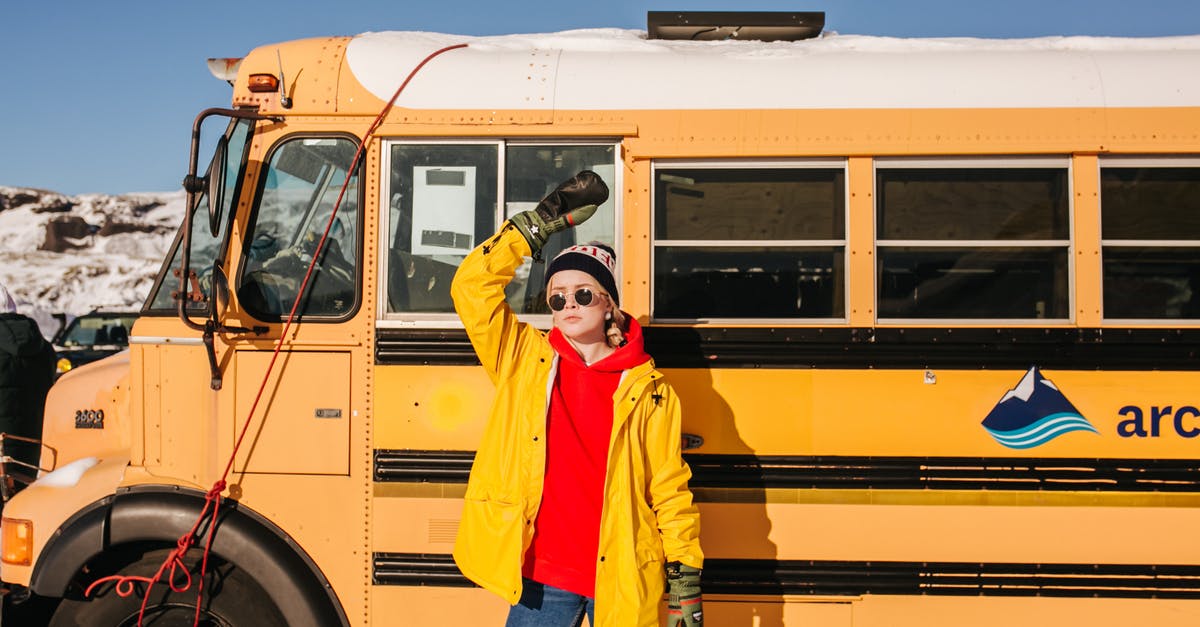 What clothes are necessary to visit Iceland in July? - A Parked Bus Behind a Stylish Woman