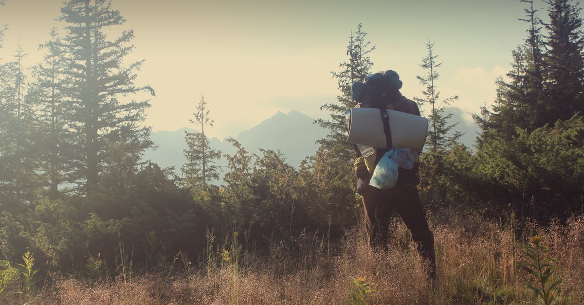 What clothes should I bring on a backpacking trip - Man Standing on Green Grass