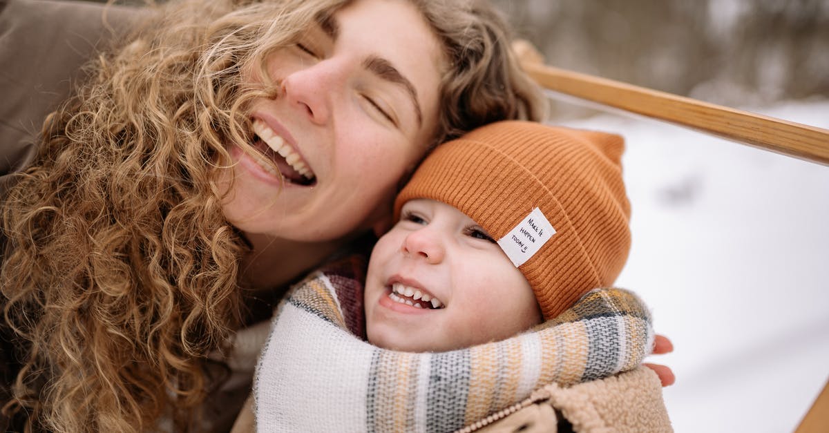 What clothing should I bring to Dubai during February? - Woman in Brown and White Knit Scarf Smiling