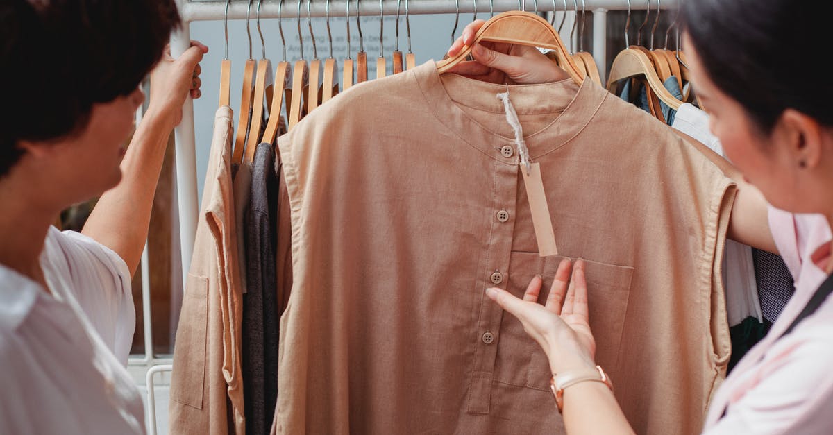 What dialect of Spanish do the locals speak in Panama City? - Crop Asian shoppers interacting while choosing clothes in shop