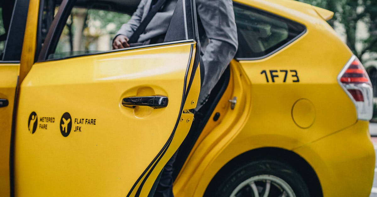 What do these numbers (1, 2, 3) on taxi roofs mean? - Black man in elegant suit opening door of yellow taxi