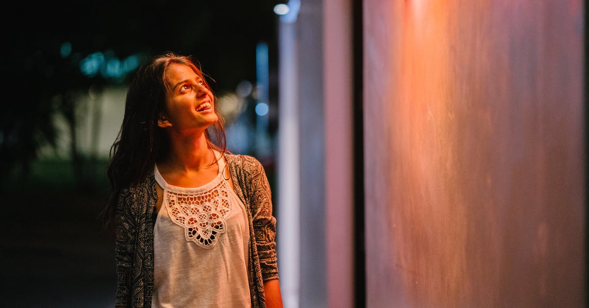 What does a Sri Lankan visa for Indians look like? - Woman in Gray Cardigan Standing Near Wall during Nighttime